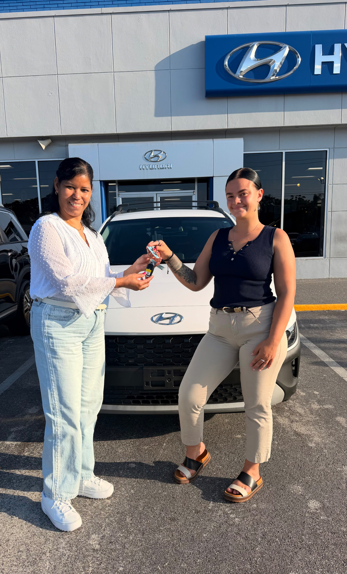 Alexis with a customer receiving keys to a new white Hyundai